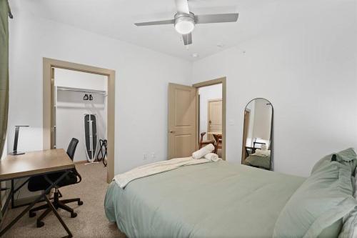 a bedroom with a bed and a desk and mirror at Luxe 2B/2B Getaway - Pool, Gym, Garage, Pet Wash in Leander
