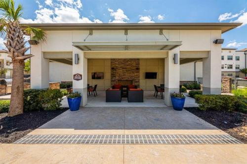 a house with a patio and a palm tree at Luxe 2B/2B Getaway - Pool, Gym, Garage, Pet Wash in Leander