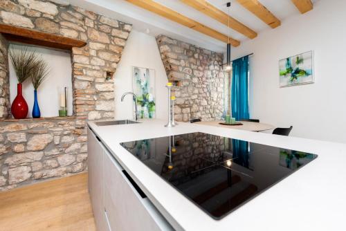 eine Küche mit einem großen Fenster und einer Steinmauer in der Unterkunft Casa Rosa 1 in Rovinj