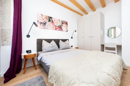 ein weißes Schlafzimmer mit einem großen Bett und lila Vorhängen in der Unterkunft Casa Rosa 1 in Rovinj