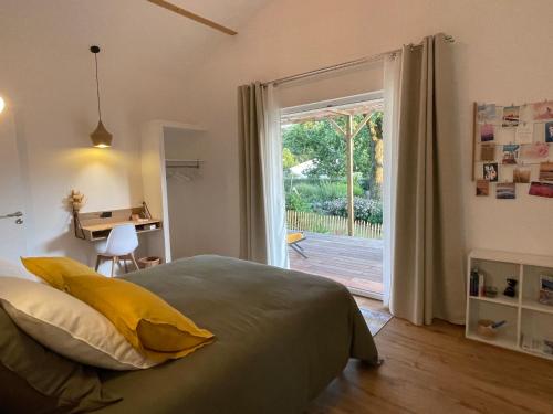 a bedroom with a bed and a sliding glass door at HARITZAGA chambre d'hôte terrasse & jardin privé in Biarritz