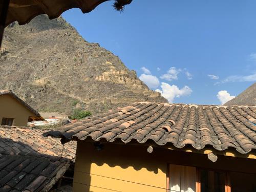 ein Dach eines Hauses mit einem Berg im Hintergrund in der Unterkunft Spa Aromas Ollantay in Ollantaytambo