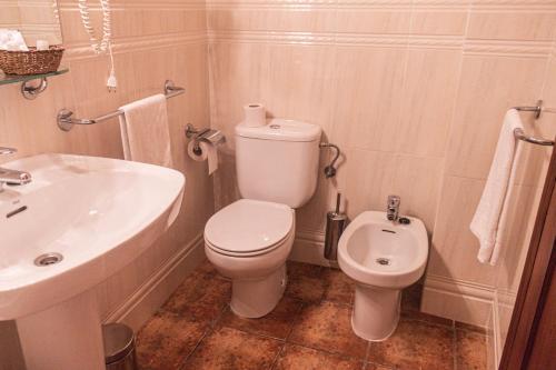 a bathroom with a white toilet and a sink at Hotel Tàrbena in Tárbena