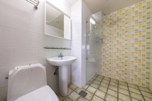 a bathroom with a white toilet and a sink at Hotel Hue in Tongyeong