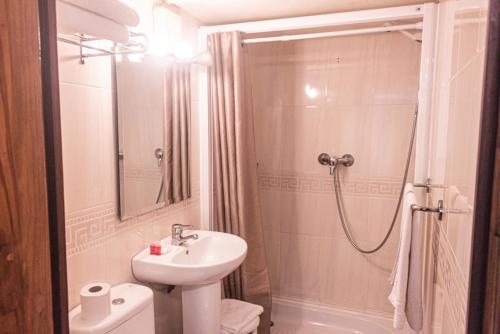 a white bathroom with a sink and a shower at Hotel Tàrbena in Tárbena