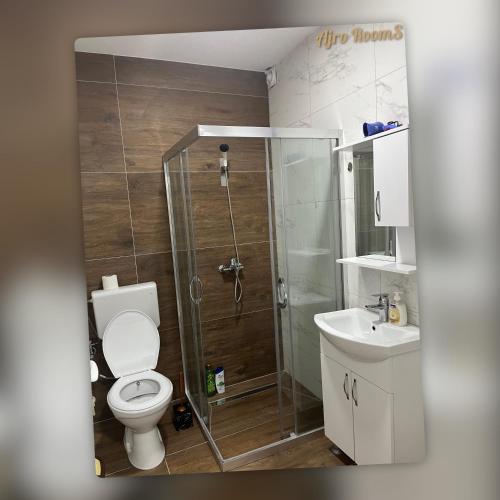 a bathroom with a shower and a toilet and a sink at Ajro Rooms in Struga
