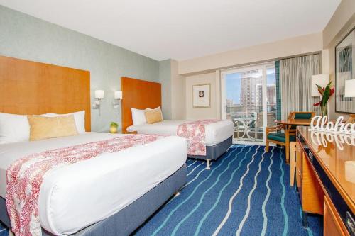 a hotel room with two beds and a balcony at Ocean views Walk to beach Waikiki and mall 1223 in Honolulu