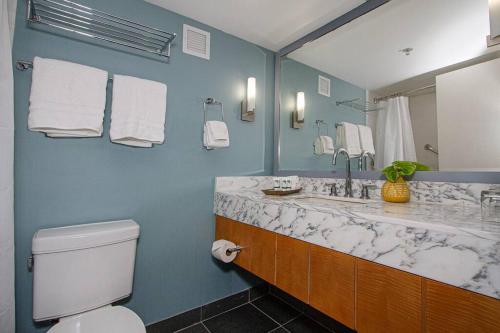 a bathroom with a sink and a toilet and a mirror at Ocean views Walk to beach Waikiki and mall 1223 in Honolulu