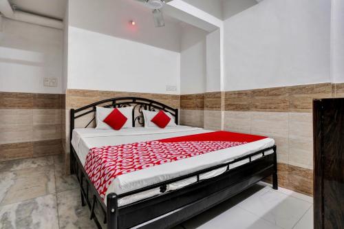 1 dormitorio con 1 cama con sábanas rojas y almohadas rojas en OYO Flagship Goodwill Lodging, en Bombay