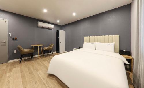 a bedroom with a bed and a table and chairs at Hotel Laon in Tongyeong