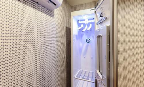 małą lodówkę w pokoju ze ścianą w obiekcie Hotel Laon w mieście Tongyeong
