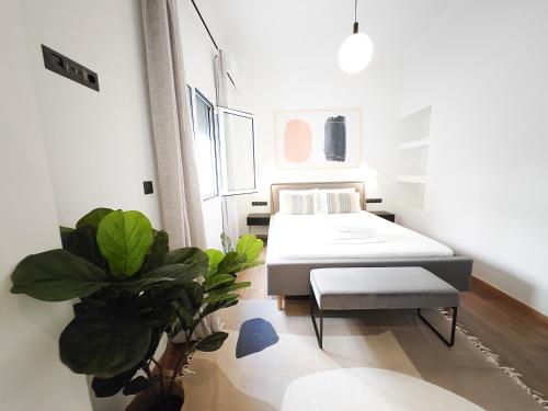 Cette chambre comprend un lit et une plante. dans l'établissement SAV12 Family Apartment Patisia Athens, à Athènes