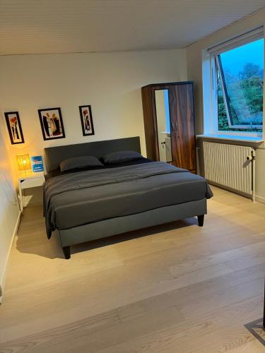 a bedroom with a bed and a large window at Private Room in Billund centre close to Lego House & Legoland in Billund