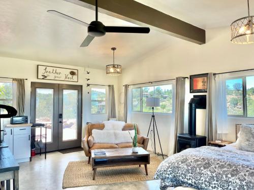 a bedroom with a bed and a chair and windows at NEW Feather Your Nest King bed Casita, Balcony/BBQ, Amazing views & great Location! Dog friendly in Prescott