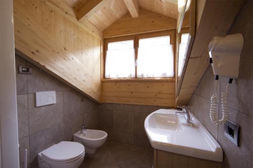 une salle de bain avec un lavabo et des toilettes et une fenêtre dans l'établissement Casa Marizzoni, à Peio Fonti