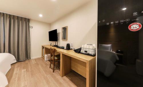 a hotel room with a desk and a computer in a room at Hotel Laon in Tongyeong