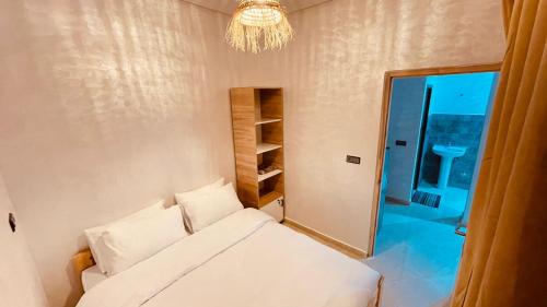 a bedroom with a bed and a mirror and a chandelier at WOW beach house in Imsouane