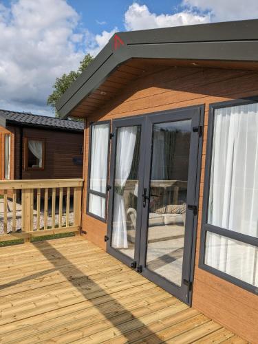 a house with sliding glass doors on a deck at Waterfoot Lodge in Little Habton