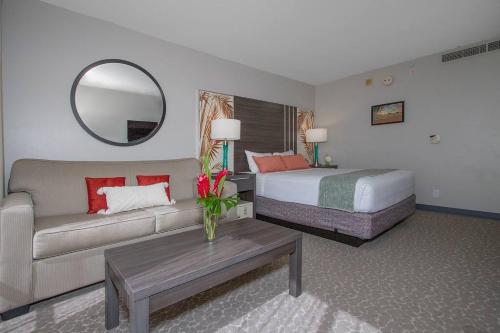 une chambre d'hôtel avec un canapé, un lit et un miroir dans l'établissement Modern studio Across From Hilton lagoon beach PW920, à Honolulu