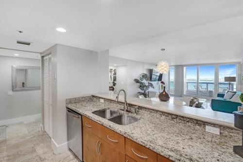 a kitchen with a sink and a view of the ocean at The Audrey! Penthouse With Direct Water Views! in Miami