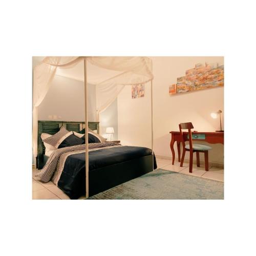 a bedroom with a canopy bed and a table at Villa Mia in Abidjan