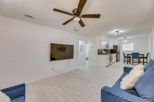 a living room with a blue couch and a ceiling fan at Modern Home in Edinburg Half-Mi Walk to UTRGV! in Edinburg