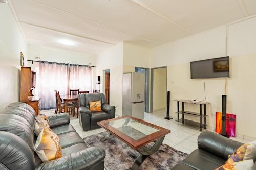a living room with a couch and a table at Wood Road Guest Lodge in Victoria Falls