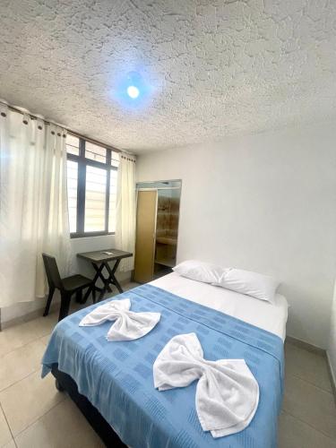 a bedroom with a blue bed with towels on it at Casa Santiago Mayor in Cali