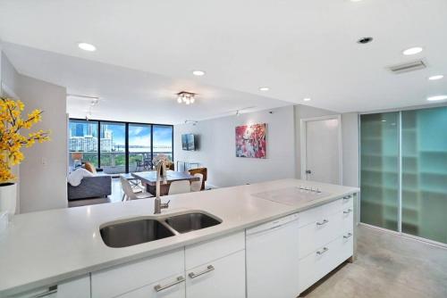 a kitchen with a sink and a living room at Shore to Please! Park And Water Views! in Miami