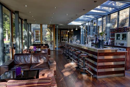 a restaurant with leather furniture and a bar at Best Western Plus Sheffield Mosborough Hall Hotel in Sheffield