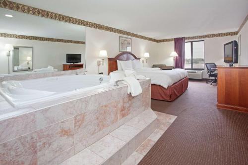 a hotel room with a large tub and a bed at Hampton Inn Bowling Green in Bowling Green