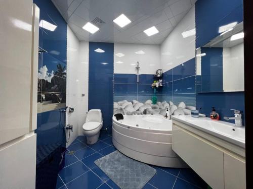 a blue and white bathroom with a tub and a toilet at Park Azure 463 in Baku