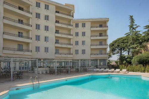 een hotel met een zwembad voor een gebouw bij NH Caltagirone Villa San Mauro in Caltagirone
