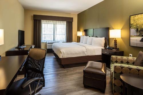 a hotel room with a bed and a desk at Best Western Plus Franciscan Square Inn & Suites Steubenville in Steubenville