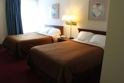 a hotel room with two beds and a window at Rodeway Inn in Little Falls