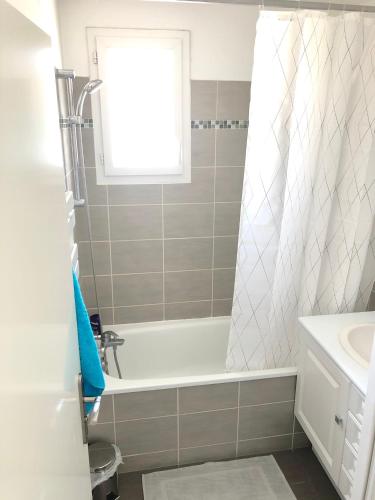 une salle de bain avec une baignoire et un lavabo dans l'établissement Lovely Disney House, à Magny-le-Hongre