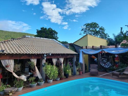 a house with a swimming pool and a house with a shed at Pousada Cantinho de Casa in Nobres