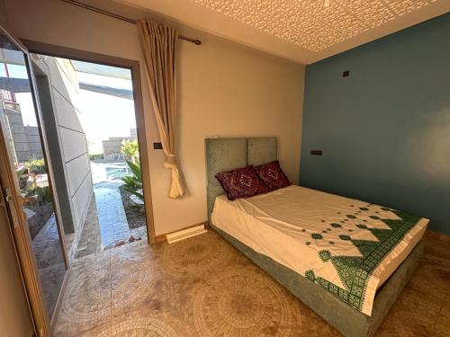 a bedroom with a bed and a glass door at Ferme Marsa in Guercif