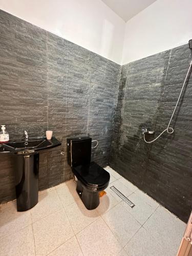 Łazienka z czarną toaletą i umywalką w obiekcie Ferme Marsa w mieście Guercif