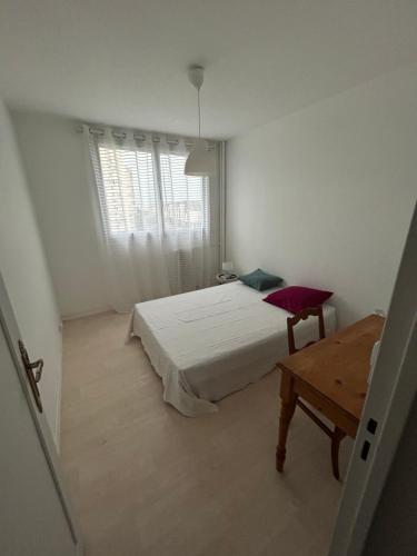 een slaapkamer met een bed, een tafel en een raam bij Appartement lumineux et spacieux centre de Tours in Tours