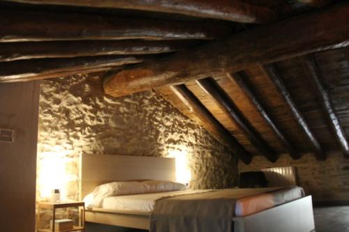 - une chambre avec un lit dans un mur en pierre dans l'établissement Casa Rústica y vistas a la montaña - Els Llavadors, à Villafranca del Cid