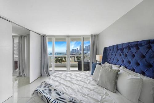 um quarto com uma cama grande e uma cabeceira azul em The Marilyn! Renovated and Amazing Skyline Views! em Miami