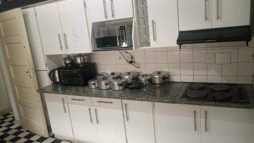 uma cozinha com armários brancos, um fogão e um micro-ondas em Manor house em Durban