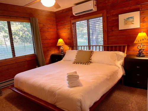 ein Schlafzimmer mit einem Bett in einem Blockhaus in der Unterkunft A Cozy Cabin Escape in Tijeras-Hot Tub-Game room-Pet Friendly! in Tijeras