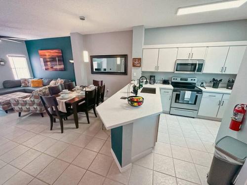 a kitchen and living room with a table and a couch at Roomy House Near Disney with Resort Pool and Patio BBQ in Kissimmee
