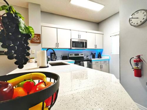 a kitchen with a bowl of fruit on a counter at Roomy House Near Disney with Resort Pool and Patio BBQ in Kissimmee