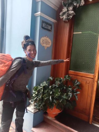 a woman standing in front of a building with a plant at Villa Bonita Hostel in Riobamba