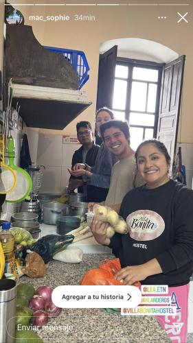 a group of people standing in a kitchen preparing food at Villa Bonita Hostel in Riobamba