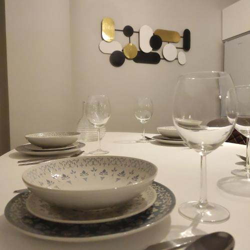 a table with plates and wine glasses on it at Apartamento Suite 48- Recién reformado in Avilés