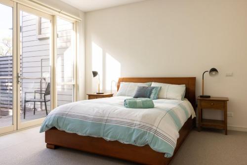 een slaapkamer met een groot bed en een balkon bij One Level at Broadbeach Inverloch in Inverloch